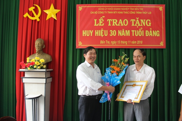 Đồng chí Hồ Ngọc Hậu đại diện Chi bộ tặng hoa cho đồng chí Nguyễn Văn Đức Lớn